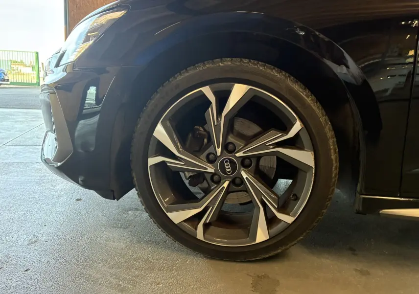 Gros plan sur la roue avant gauche noire d'une Audi A3 Sportback 2022 avec jante alliage au design moderne.