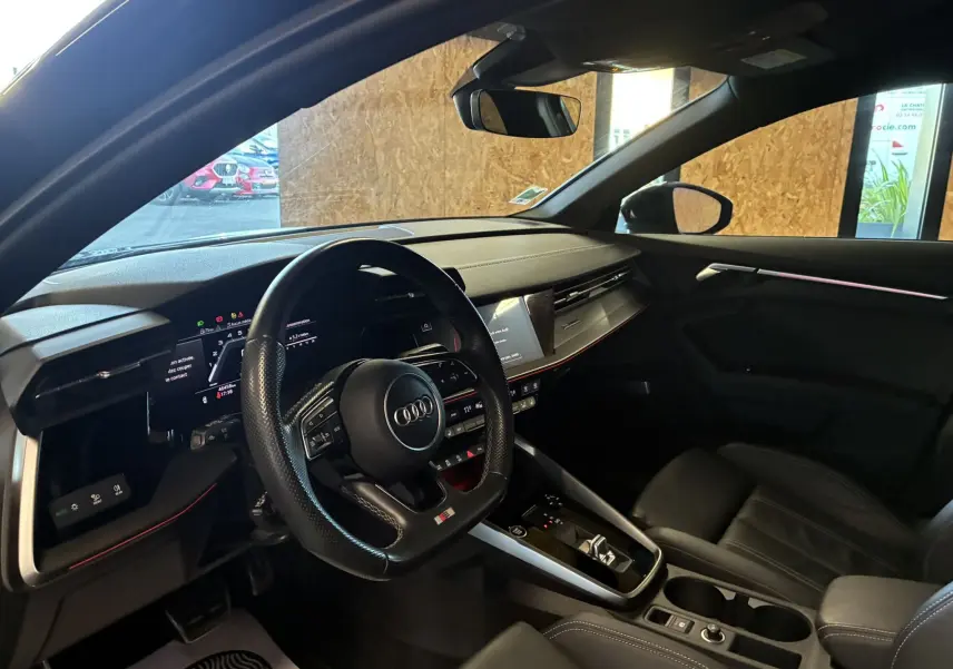 Intérieur noir de l'Audi A3 Sportback 2022, vue côté conducteur sur le tableau de bord et volant multifonction S Line.