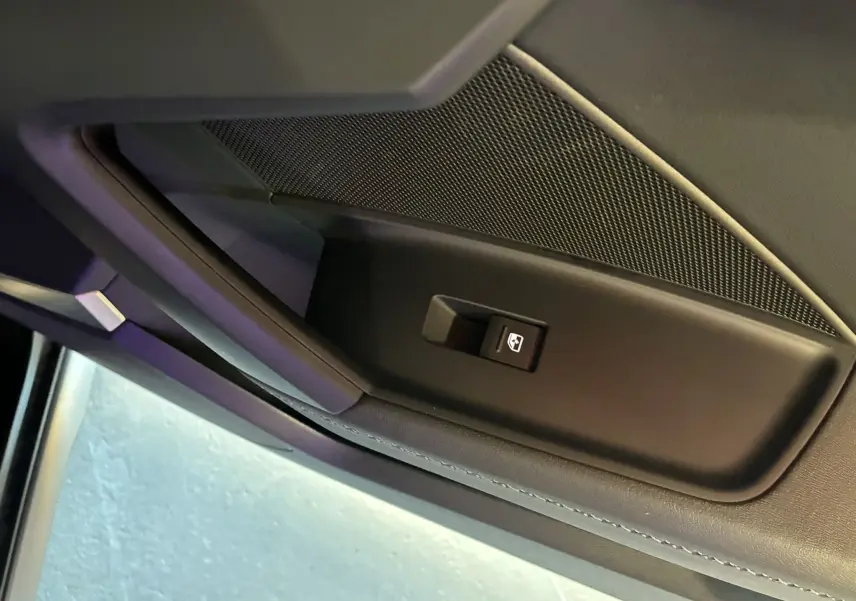 Détail de la commande de lève-vitre sur la porte intérieure côté gauche d'une Audi A3 Sportback noire 2022.