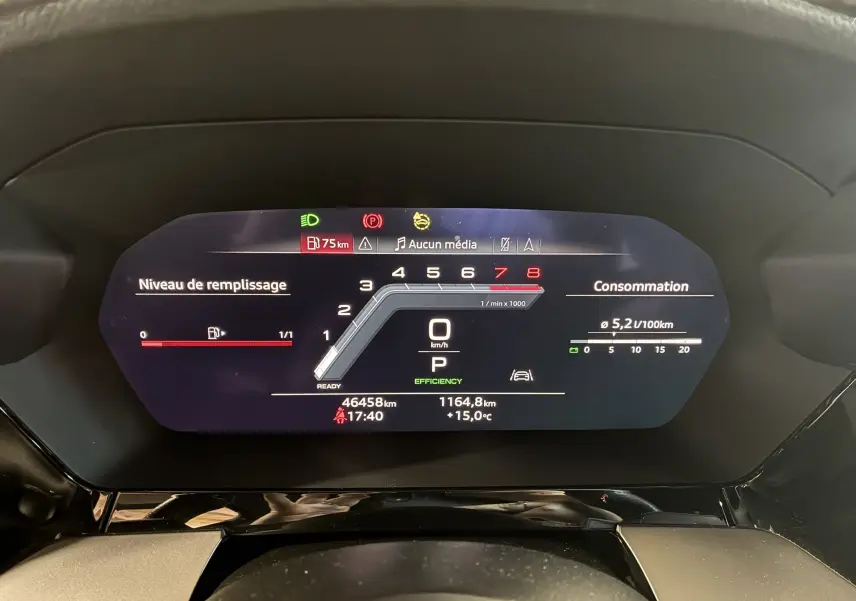 Tableau de bord numérique de l'Audi A3 Sportback noir, affichant vitesse, consommation et niveau de carburant.