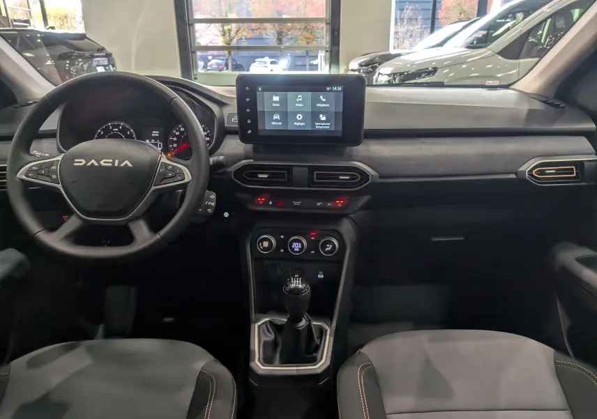 Intérieur de la Dacia Sandero Stepway TCe 110 2025, vue frontale du tableau de bord et volant noir avec écran tactile central.
