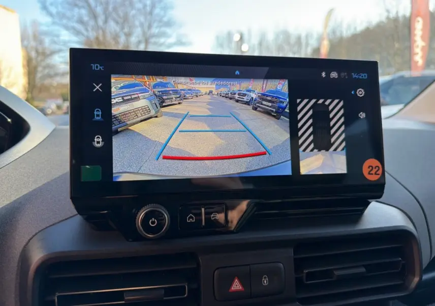 Écran tactile intérieur montrant la caméra de recul du Peugeot Rifter blanc kaolin, tableau de bord en arrière-plan.