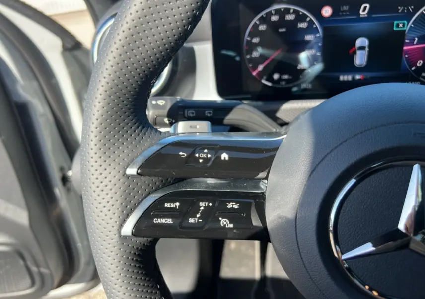 Gros plan sur le volant cuir perforé de la Mercedes Classe A 200D 2026 avec commandes multifonctions et tableau de bord numérique.