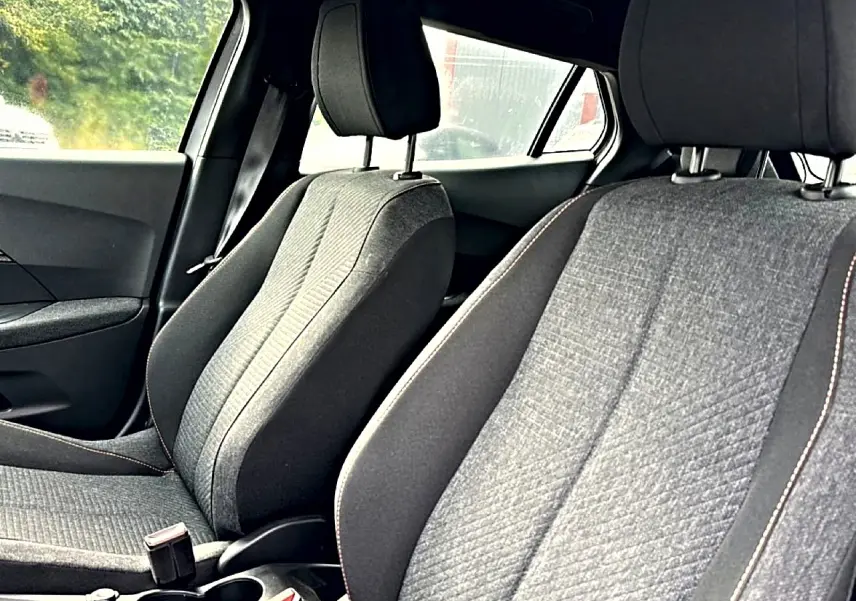 Vue intérieure rapprochée des sièges avant gris du Peugeot 2008 1.2 hybrid 145 style e-dcs6 2025.