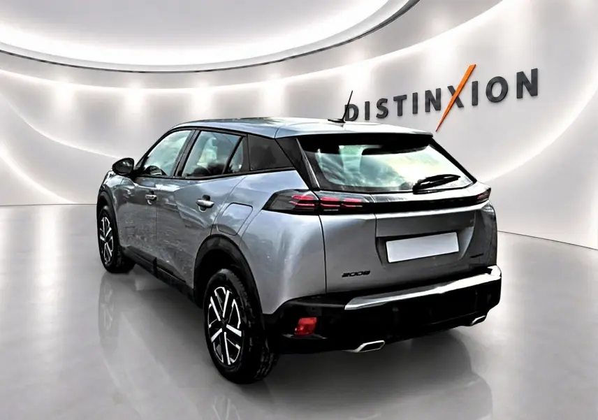 Peugeot 2008 gris en 3/4 arrière droit, avec feux arrière LED et jantes noires à motifs argentés.