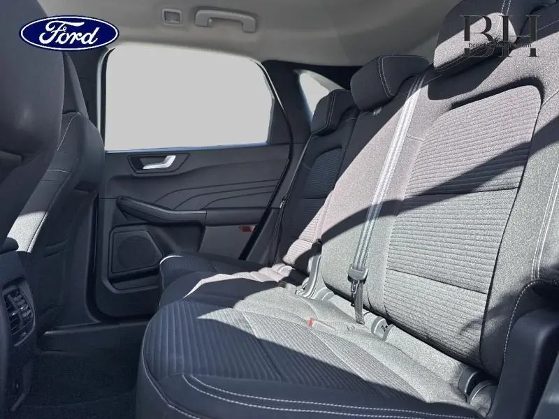 Vue intérieure côté gauche des sièges arrière en tissu gris du Ford Kuga 2023, soulignant l'espace et les ceintures de sécurité.