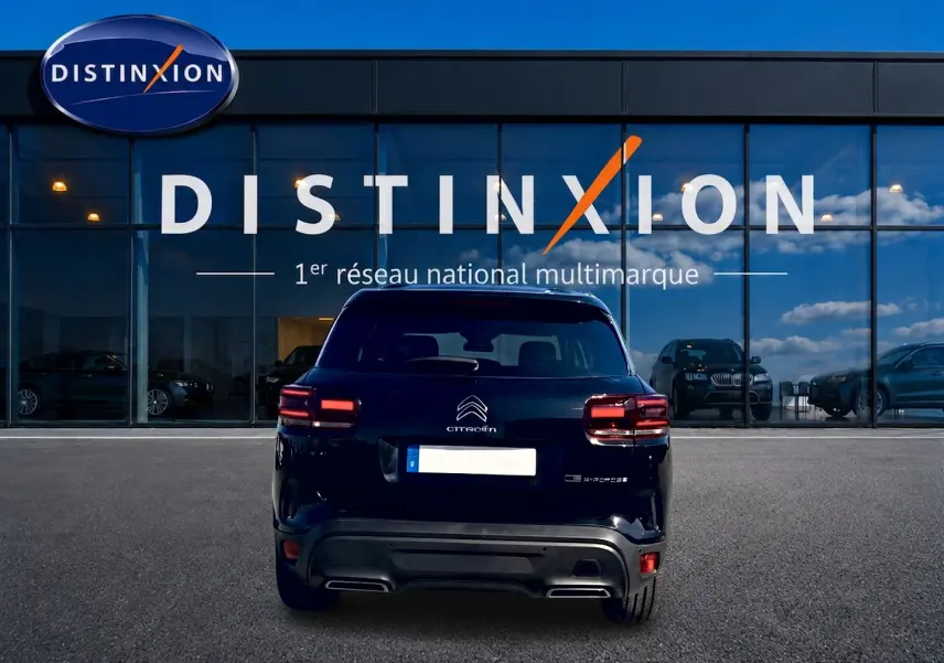 Vue arrière d'un Citroën C5 Aircross noir 2024, avec feux LED et logo Citroën bien visibles, devant une vitrine Distinxion.