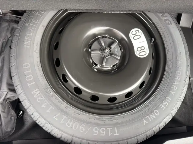Gros plan sur la roue de secours temporaire noire du coffre du Renault Austral Techno full hybrid bleu 2026.