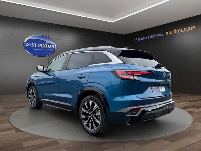Vue 3/4 arrière droite du Renault Austral bleu bi-ton avec hayon motorisé et jantes alliage distinctives.