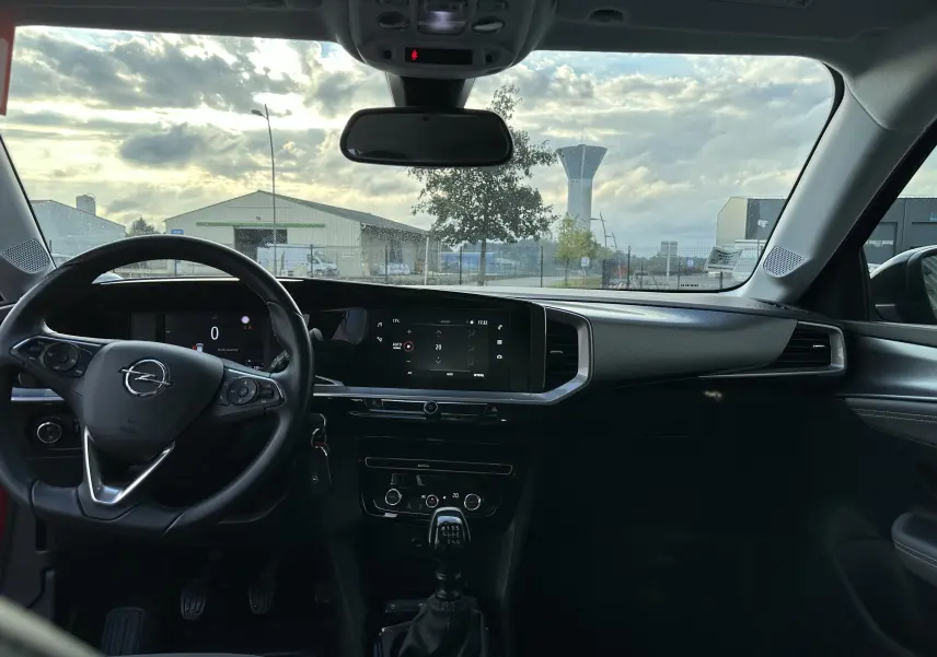 Intérieur de l'Opel Mokka Elegance 2021, vue frontale du tableau de bord avec volant, écran tactile et levier de vitesses manuel.