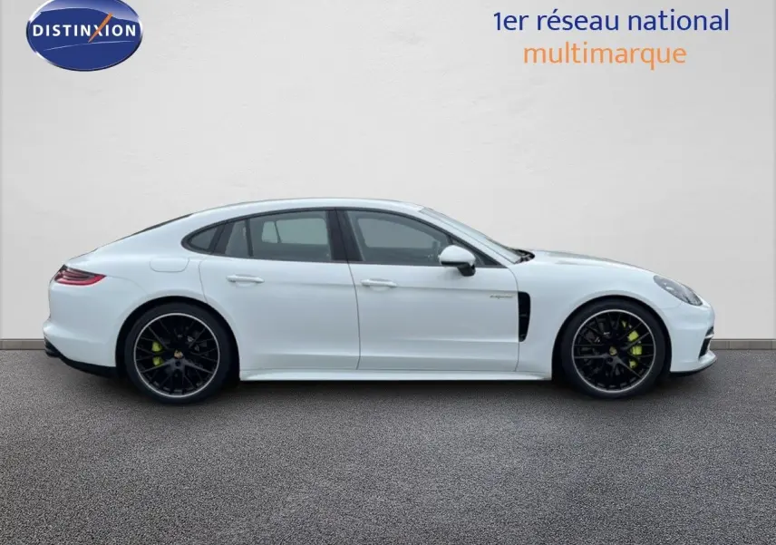 Profil droit d'une Porsche Panamera 4 E-Hybrid blanche avec jantes sport noires et étriers verts visibles.