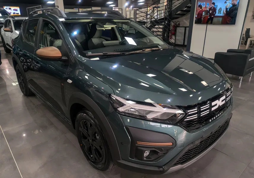 Dacia Sandero Stepway TCe 110 vert cèdre en 3/4 avant droit, avec rétroviseurs bronze et jantes noires en showroom.