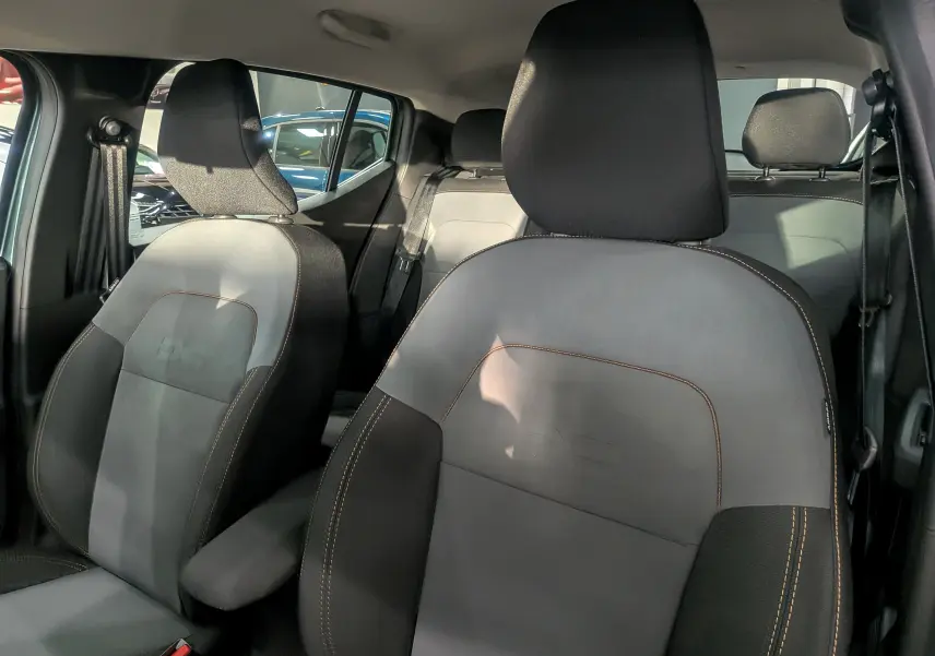 Intérieur montrant les sièges avant en tissu gris et noir avec surpiqûres contrastantes d'une Dacia Sandero Stepway 2025.
