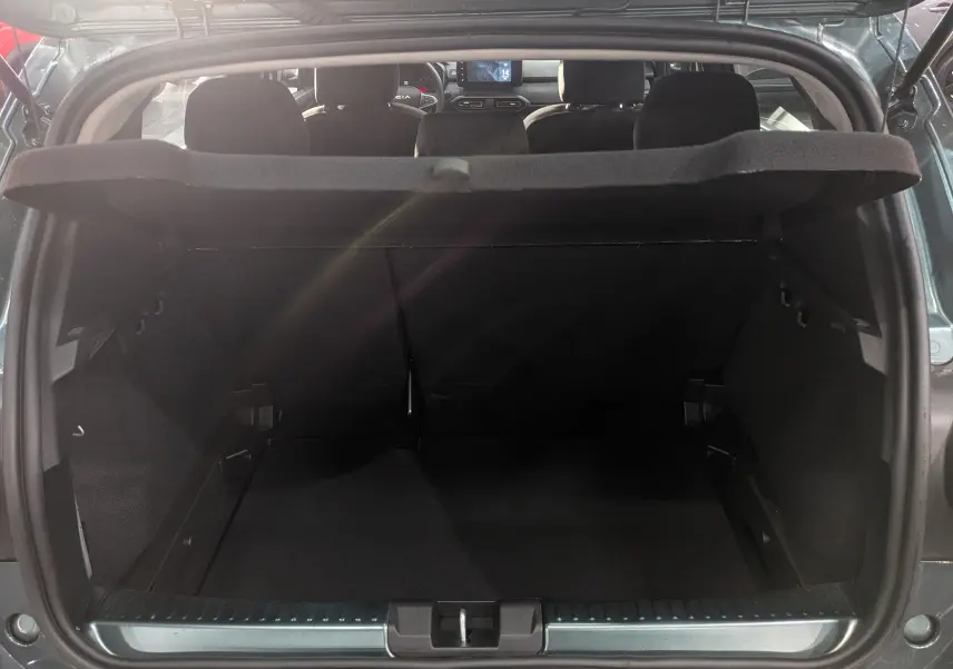 Coffre ouvert d'une Dacia Sandero Stepway TCe 110 Vert Cèdre, vue arrière montrant l'habitacle et la tablette de séparation.