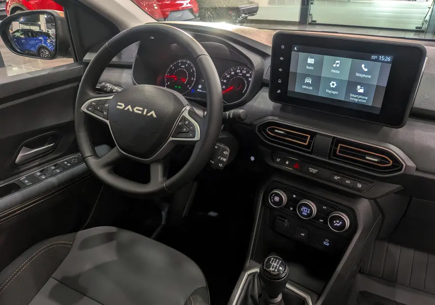 Vue intérieure côté conducteur du tableau de bord et volant DACIA Sandero Stepway 2025 avec écran tactile et boîte manuelle.