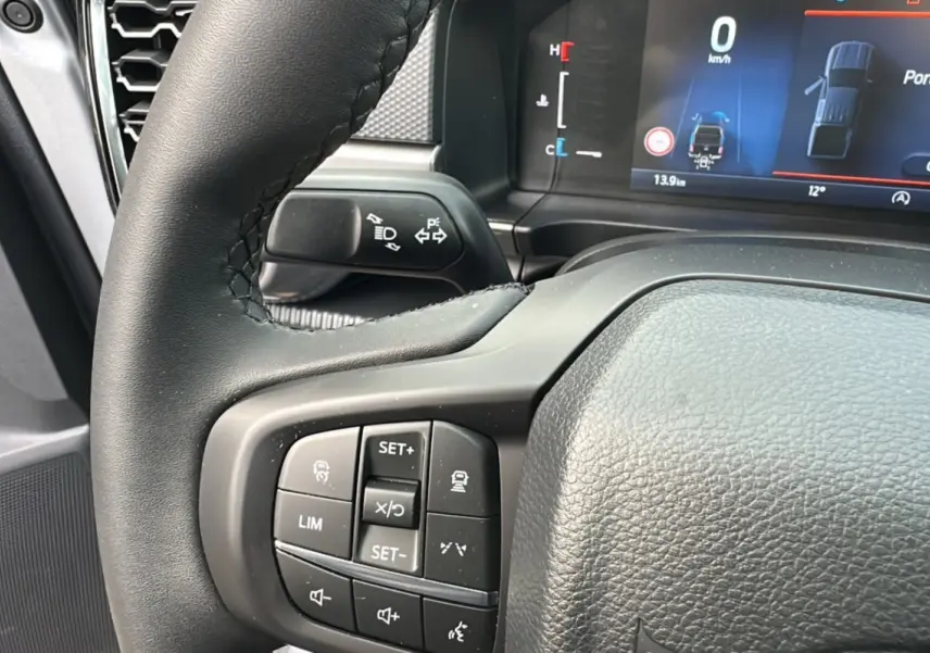 Gros plan sur le volant cuir multifonctions du Ford Ranger gris iconic avec écran digital et commandes au volant visibles.