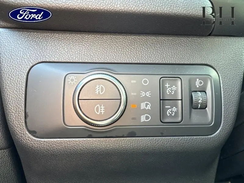 Gros plan sur le panneau de commande des phares du Ford Kuga 2022, avec réglages d’éclairage et boutons de feux antibrouillard.