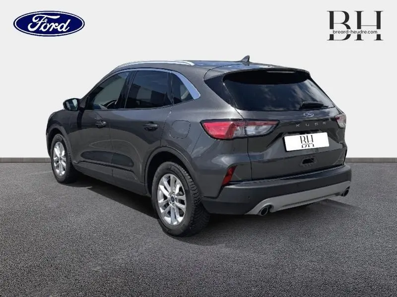 Ford Kuga gris Magnetic métallisé vu en 3/4 arrière droit avec vitres arrière surteintées et jantes alu.