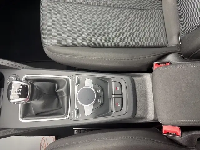 Vue plongeante sur la console centrale noire de l'Audi Q2 blanc 30 TDI 116 Design avec boîte manuelle et molette de commande.