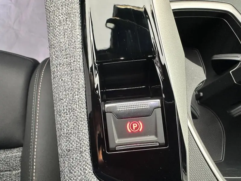 Gros plan sur le frein à main électrique rouge dans la console centrale noire du Peugeot 3008 gris Titane.