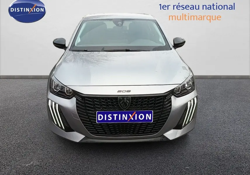 Vue frontale d’une Peugeot 208 gris Artense métal avec calandre noire et feux diurnes LED en griffes distinctives.