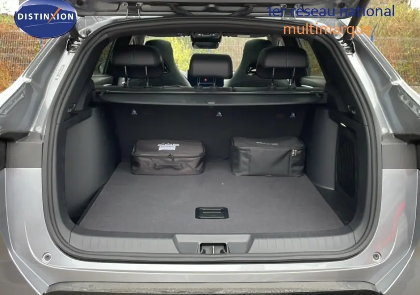 Coffre ouvert vu de l'arrière d'un BYD SEAL U 2026 gris métallisé avec deux sacs noirs à l'intérieur.