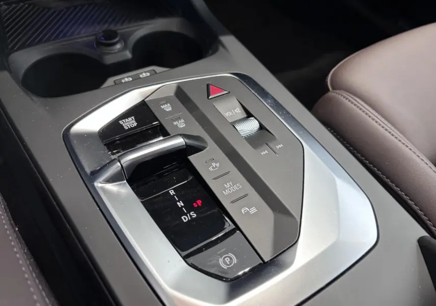 Gros plan sur la console centrale de la BMW Série 1 120d M Sport 2025, avec levier de boîte auto et commandes intégrées.