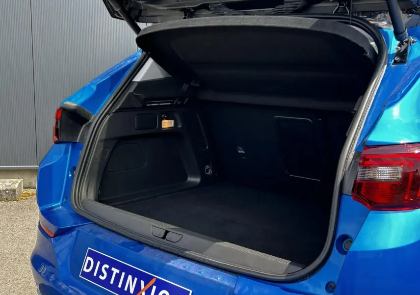 Coffre ouvert vu de l'arrière d'un Opel Grandland bleu Vertigo avec hayon électrique et feux arrière LED.
