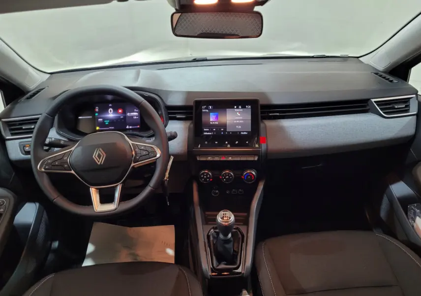Intérieur de la Renault Clio 2025 gris foncé, vue frontale du tableau de bord avec écran tactile et volant multifonctions.