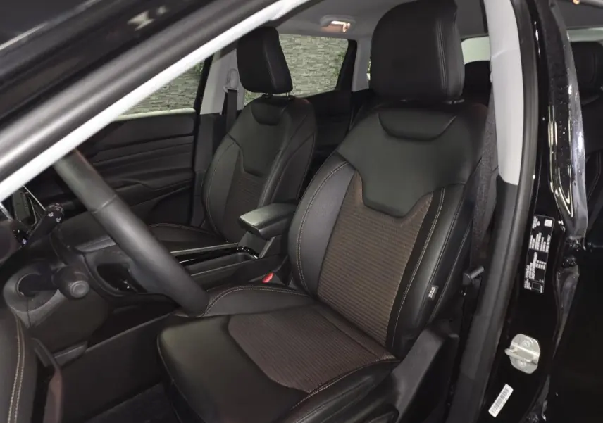 Vue intérieure côté conducteur du Jeep Compass 2024 noir, sièges avant en cuir et tissu noir avec surpiqûres bronze.