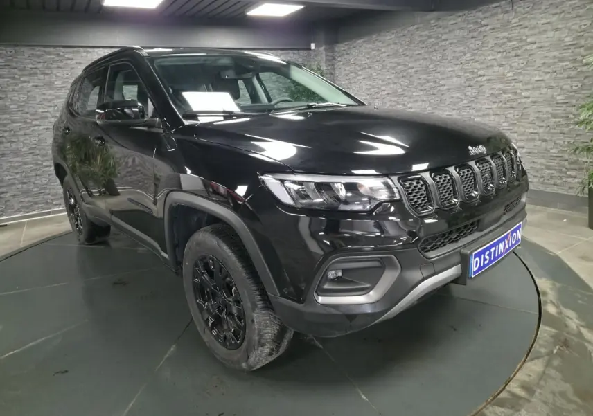 Jeep Compass noir en vue 3/4 avant droit, avec calandre distinctive et jantes alliage noires brillantes.