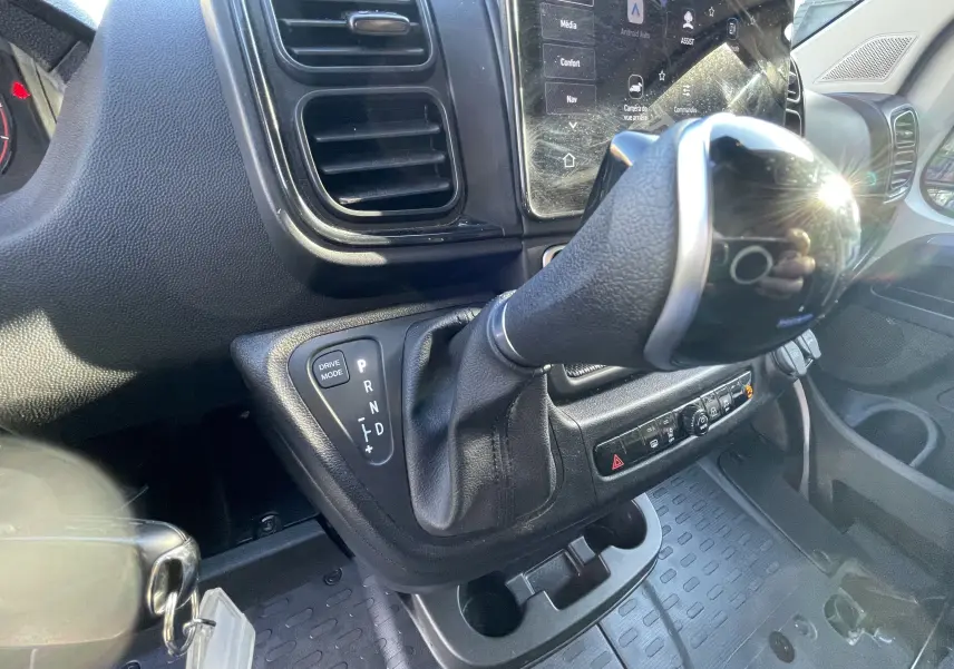 Gros plan sur le levier de vitesses automatique et la console centrale du Peugeot Boxer Fourgon blanc, intérieur avant droit.
