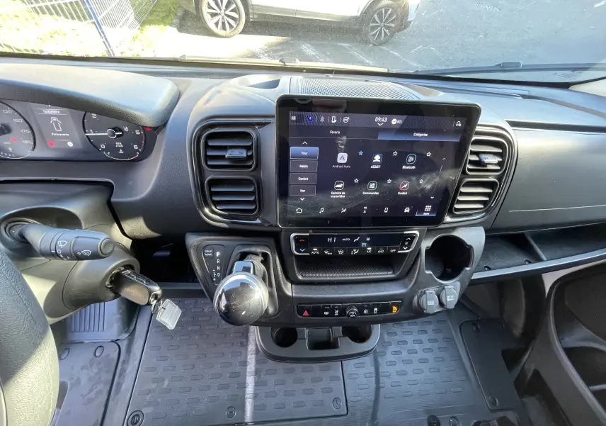 Vue intérieure du tableau de bord du Peugeot Boxer Fourgon blanc 2025, avec écran tactile central et levier de vitesse automatique.