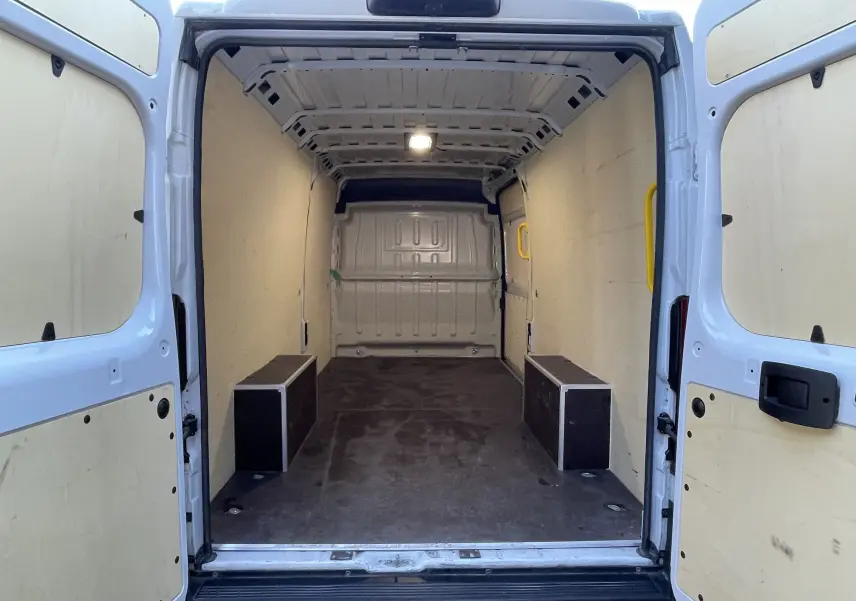 Vue arrière intérieure du Peugeot Boxer Fourgon blanc 2025, montrant l'espace de chargement vide avec portes ouvertes.