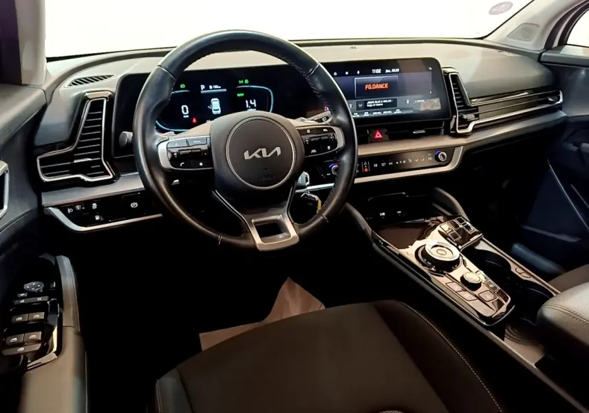 Vue intérieure du tableau de bord et volant noir du Kia Sportage hybride rechargeable 2022, avec écran tactile large.
