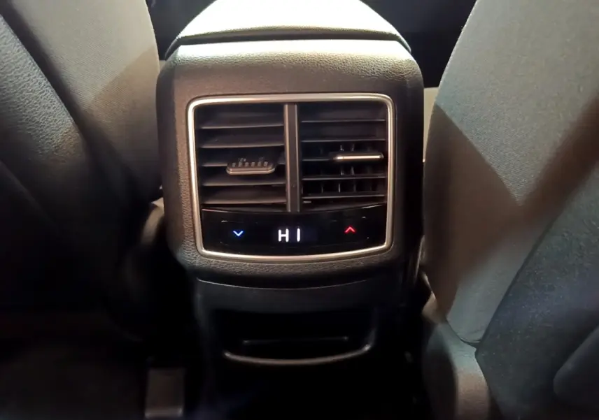 Détail de la commande de climatisation arrière digitale du Kia Sportage 2022, entre les sièges noirs.