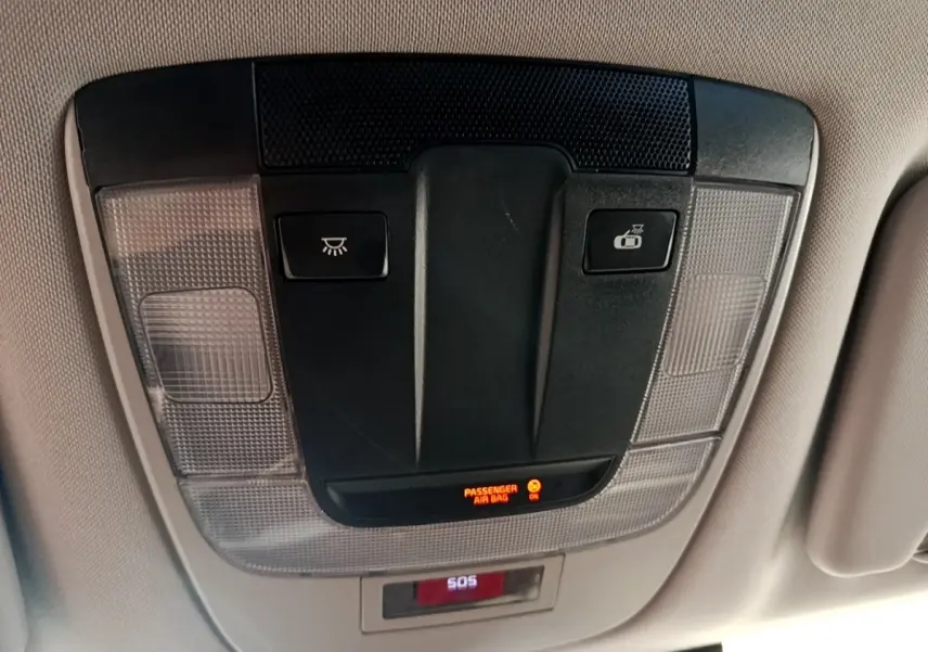 Vue intérieure du plafonnier avec commandes d’éclairage et indicateur airbag passager allumé sur Kia Sportage blanc 2022.