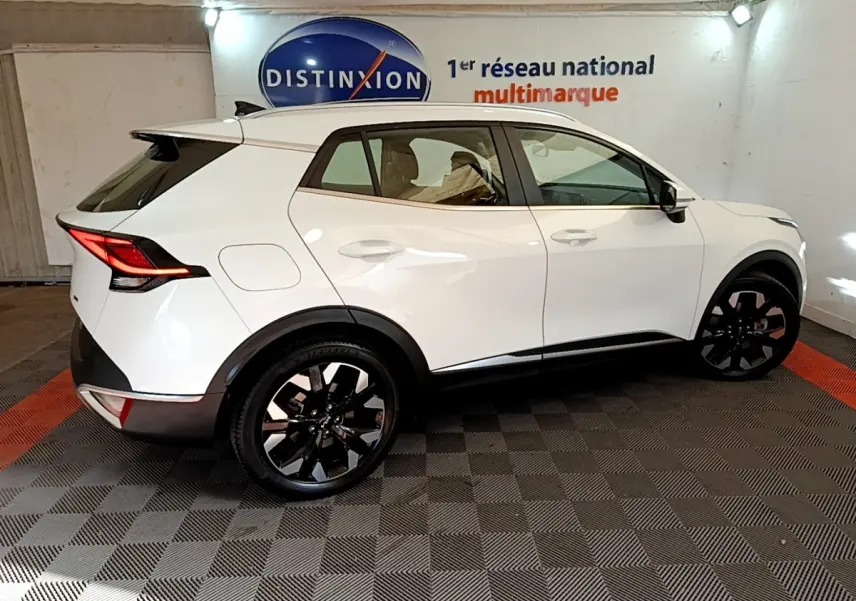 KIA Sportage blanc vue de profil côté gauche, jantes noires, feux arrière LED et toit avec spoiler.