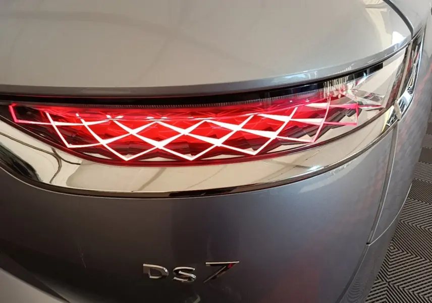 Gros plan sur le feu arrière droit rouge à motif géométrique du DS7 Crossback gris foncé.