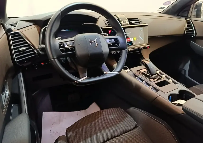 Vue intérieure côté conducteur du DS7 Crossback E-TENSE 225 Business 2021, volant cuir noir et écran tactile central.
