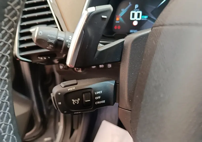 Gros plan sur le volant cuir noir de la DS7 Crossback E-TENSE 225, avec commandes de régulateur de vitesse visibles.