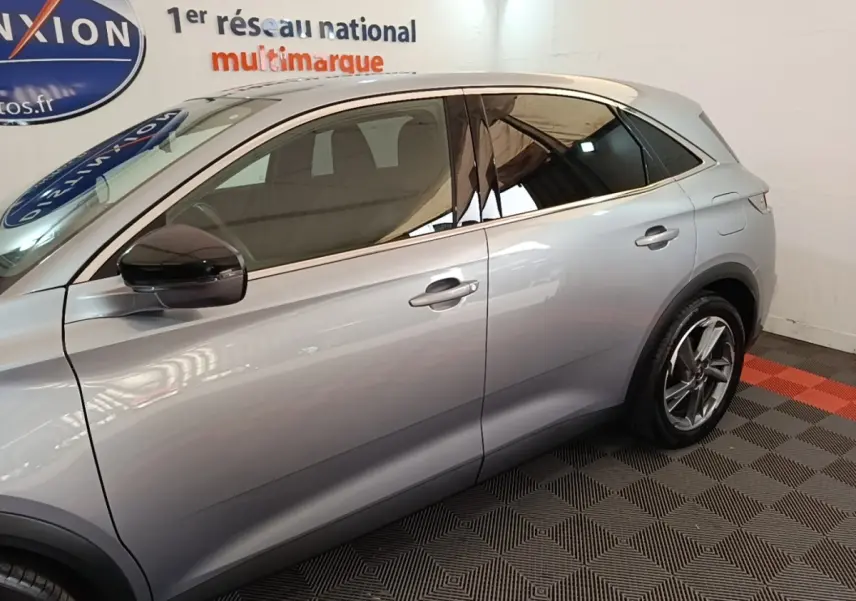 Profil côté gauche d'un DS7 Crossback E-TENSE 225 Business gris foncé avec jantes alliage et vitres teintées.