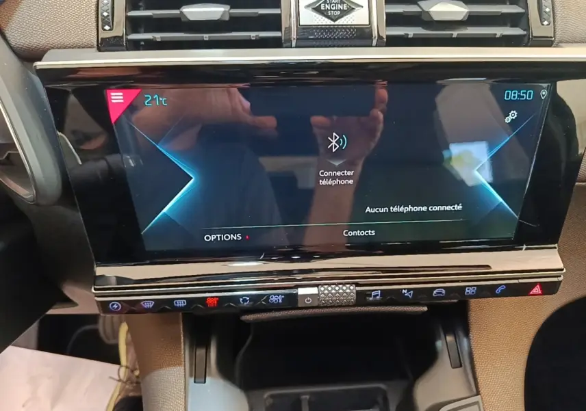 Vue rapprochée de l'écran tactile central et des commandes du tableau de bord du DS7 Crossback E-TENSE gris foncé.