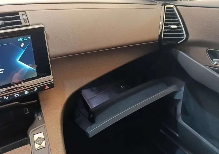 Intérieur de la DS7 Crossback E-TENSE 225 Business, vue côté passager sur la boîte à gants ouverte et écran tactile.