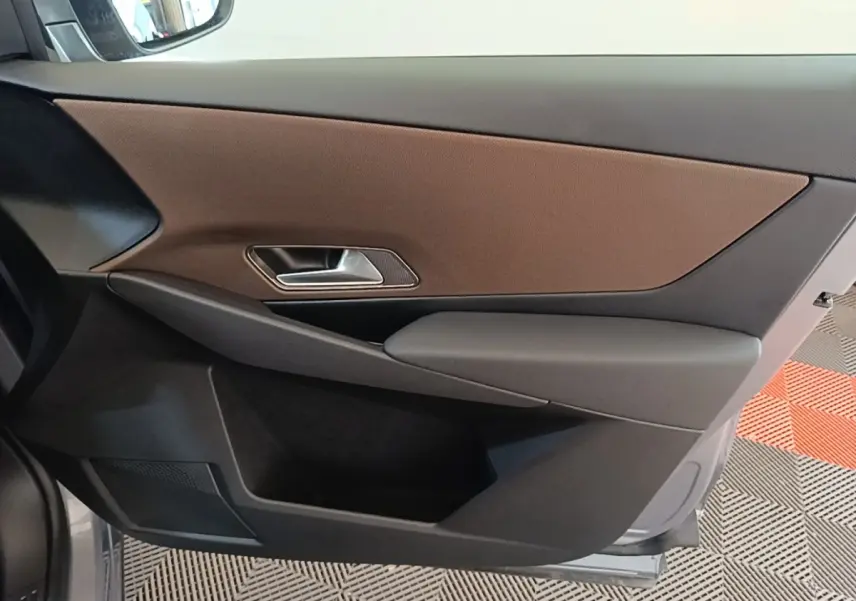 Vue intérieure côté gauche de la porte avant d'une DS7 Crossback 2021, garniture marron et noire avec poignée métallique.