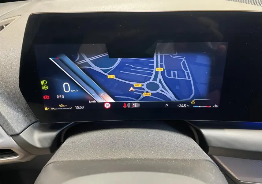 Affichage numérique du tableau de bord BMW Série 1 120d M Sport avec navigation et indicateurs, vue frontale rapprochée.