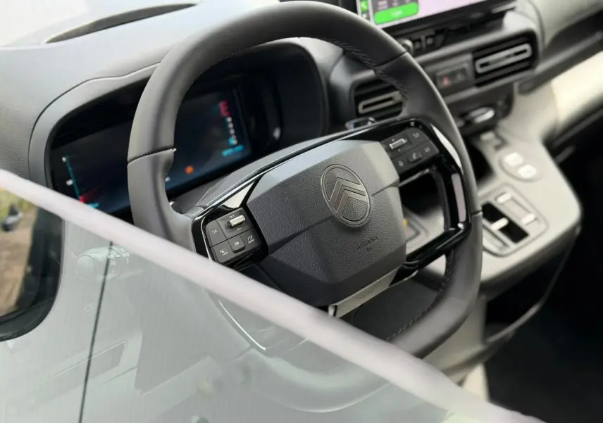 Vue intérieure rapprochée du volant multifonctions cuir et du combiné numérique du Citroën Berlingo Multispace 2026.