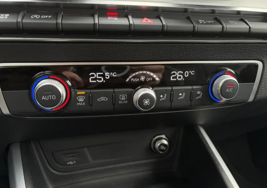 Gros plan sur la console de climatisation automatique bicolore avec réglages digitaux de l'Audi Q2 blanc Glacier 2024.