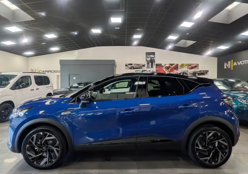 Profil côté gauche du Renault Captur E-TECH Full Hybrid 160 CH esprit Alpine bleu Iron avec toit noir en showroom.