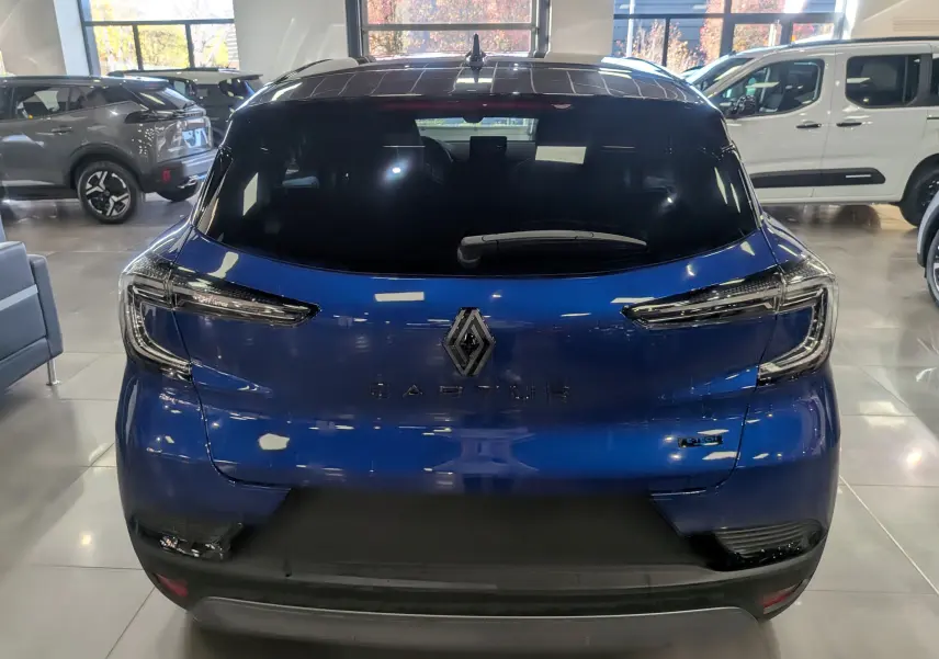 Vue arrière d'un Renault Captur E-TECH bleu Iron avec toit noir, mettant en valeur ses feux LED et logo central.